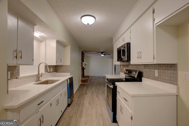 kitchen featuring range with electric stovetop, dishwashing machine, a textured ceiling, stainless steel microwave, and a sink