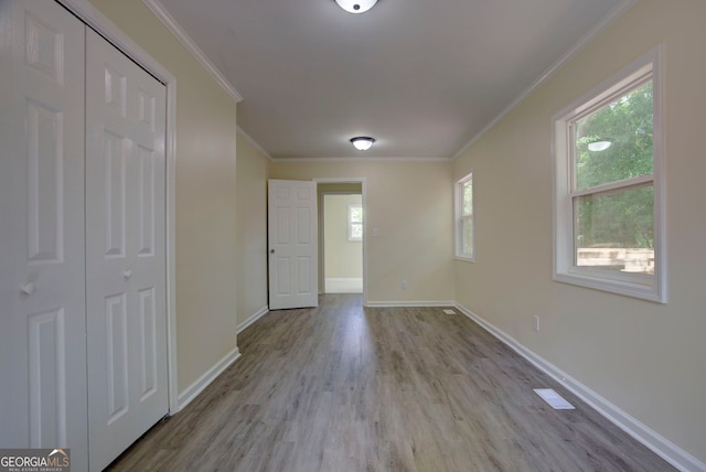 interior space with crown molding, baseboards, and wood finished floors