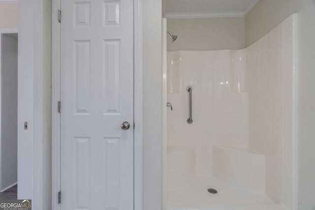 bathroom with ornamental molding and a shower
