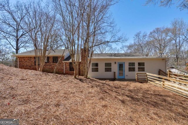rear view of property with fence and a chimney