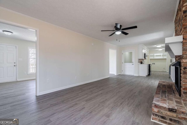 unfurnished living room with baseboards, a ceiling fan, dark wood-style flooring, and a fireplace