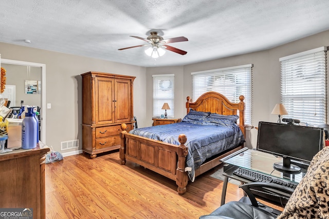 9224 Snipe Ln, Jonesboro, GA 30236 - bedroom with light wood finished floors, ceiling fan, and a textured ceiling