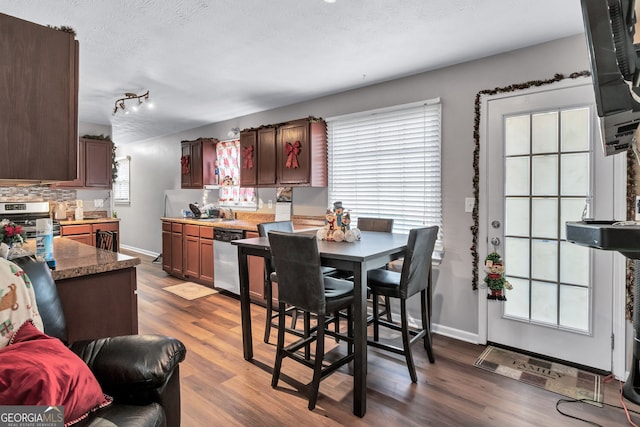 9224 Snipe Ln, Jonesboro, GA 30236 - dining space featuring dark wood finished floors, a textured ceiling, and baseboards