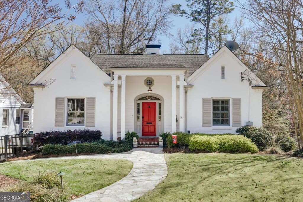 view of front of house with a front lawn, fence, roof with shingles, stucco siding, and a chimney