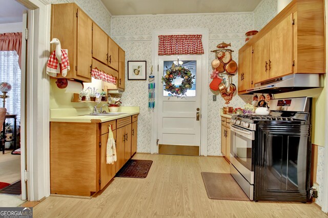 151 Flat Shoals Rd, Woodbury, GA 30293 - kitchen featuring stainless steel gas range oven, light wood finished floors, under cabinet range hood, and wallpapered walls