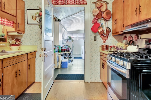 151 Flat Shoals Rd, Woodbury, GA 30293 - kitchen featuring wallpapered walls, under cabinet range hood, gas range, light wood-type flooring, and a sink