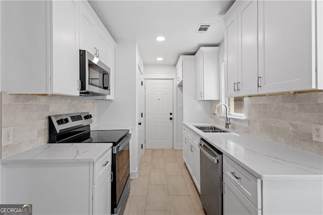 5225 Maple Valley Rd SW, Mableton, GA 30126 - kitchen featuring appliances with stainless steel finishes, recessed lighting, white cabinetry, light stone countertops, and decorative backsplash