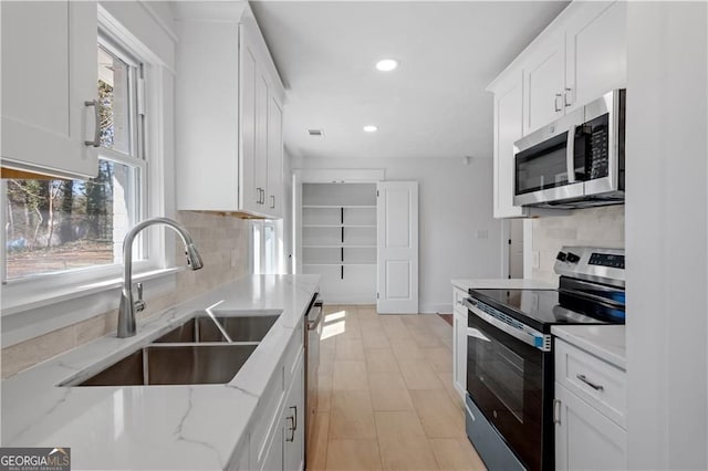 5225 Maple Valley Rd SW, Mableton, GA 30126 - kitchen featuring stainless steel appliances, white cabinets, decorative backsplash, recessed lighting, and light stone counters