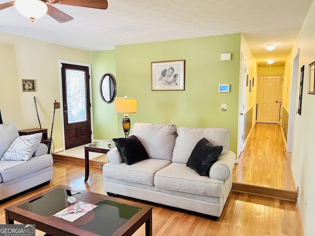 285 W0Lf Den Rd, Royston, GA 30662 - living area featuring light wood-style flooring, a ceiling fan, baseboards, and a textured ceiling