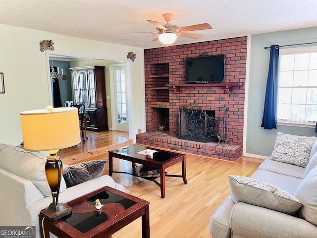 285 W0Lf Den Rd, Royston, GA 30662 - living room with a brick fireplace, plenty of natural light, a ceiling fan, light wood-style floors, and a textured ceiling