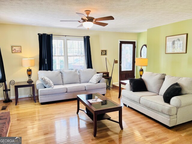 285 W0Lf Den Rd, Royston, GA 30662 - living area with a textured ceiling, light wood finished floors, a ceiling fan, and baseboards
