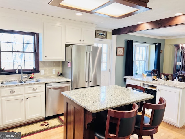 285 W0Lf Den Rd, Royston, GA 30662 - kitchen featuring appliances with stainless steel finishes, a sink, light wood-style floors, a kitchen island, and crown molding