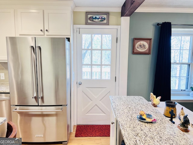 285 W0Lf Den Rd, Royston, GA 30662 - kitchen with high quality fridge, crown molding, healthy amount of natural light, white cabinetry, and light stone counters