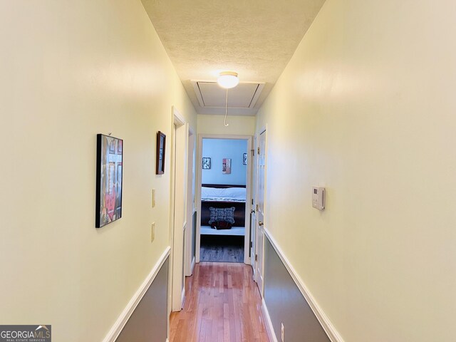 285 W0Lf Den Rd, Royston, GA 30662 - corridor with attic access, light wood-type flooring, a textured ceiling, and baseboards