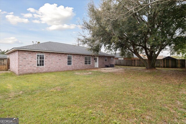 918 Summer Dr, Hinesville, GA 31313 - back of property with a lawn, brick siding, and a fenced backyard