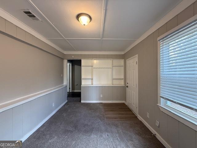 1643 Columbia Dr, Decatur, GA 30032 - unfurnished bedroom with visible vents, multiple windows, a wainscoted wall, and carpet flooring
