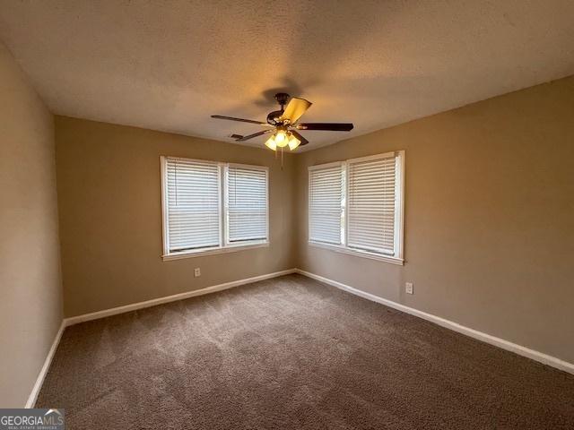 1643 Columbia Dr, Decatur, GA 30032 - spare room featuring baseboards, a textured ceiling, ceiling fan, and dark carpet