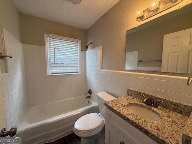 1643 Columbia Dr, Decatur, GA 30032 - full bath with a wainscoted wall, toilet, vanity, bathtub / shower combination, and tile walls