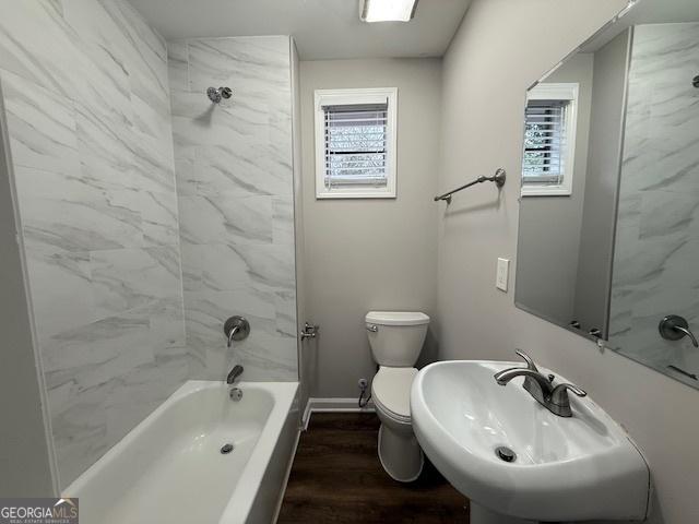 192 Margaret St, Fairburn, GA 30213 - bathroom with baseboards, toilet, wood finished floors, washtub / shower combination, and a sink