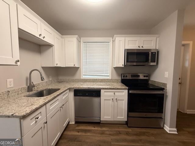 192 Margaret St, Fairburn, GA 30213 - kitchen with a sink, light stone countertops, white cabinets, stainless steel appliances, and dark wood-style flooring
