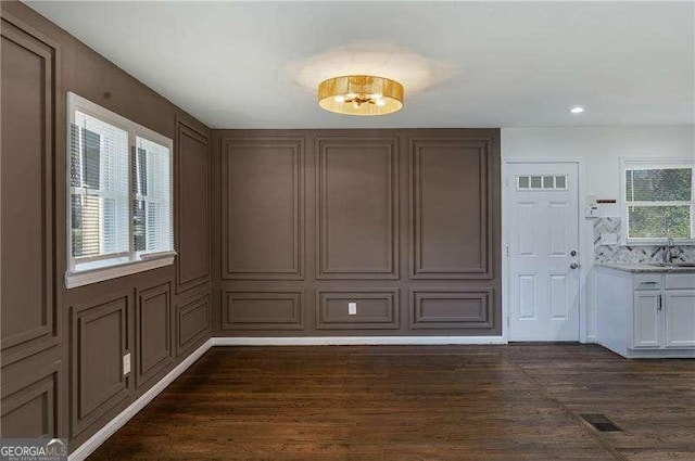 unfurnished dining area featuring visible vents, recessed lighting, dark wood-type flooring, and a sink