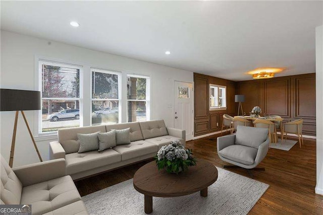living room with plenty of natural light, recessed lighting, a decorative wall, and dark wood-style flooring
