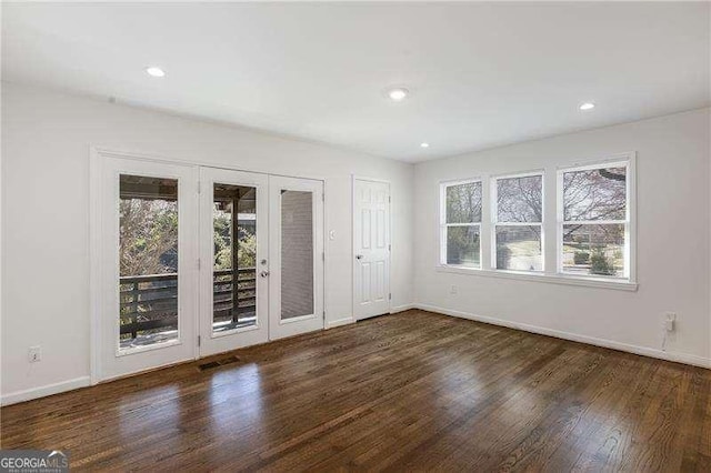 spare room with wood finished floors, recessed lighting, a healthy amount of sunlight, and baseboards