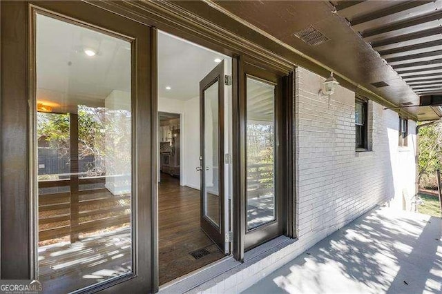 exterior space featuring visible vents and brick siding