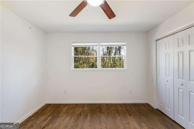 unfurnished bedroom with a closet, ceiling fan, baseboards, and wood finished floors