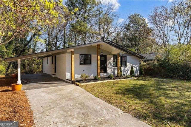 mid-century home with brick siding, an attached carport, concrete driveway, and a front lawn