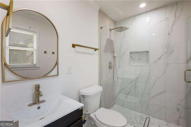 full bathroom featuring a marble finish shower, toilet, and vanity