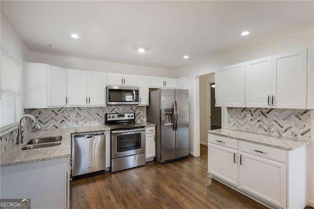 kitchen with a sink, white cabinets, dark wood-style flooring, and stainless steel appliances