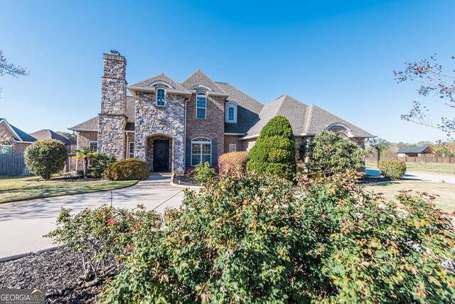 kitchen with stone countertops, arched walkways, stainless steel appliances, crown molding, and a notable chandelier