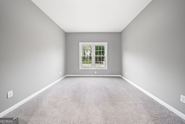 empty room featuring baseboards and carpet floors