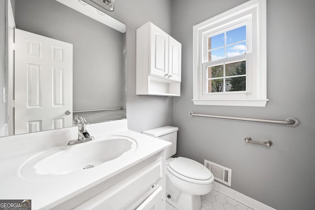 bathroom featuring toilet, vanity, tile patterned flooring, and visible vents