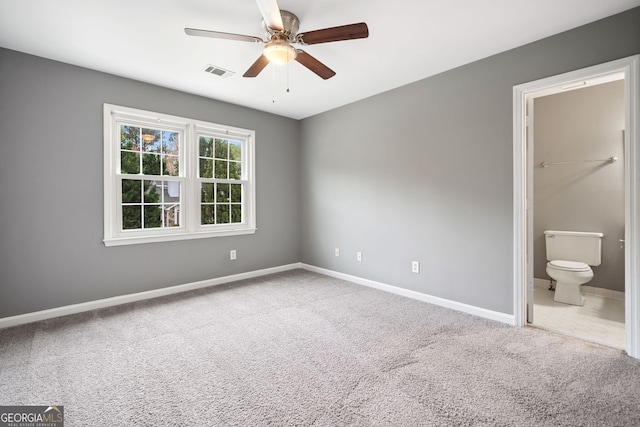 unfurnished bedroom with visible vents, baseboards, ceiling fan, connected bathroom, and carpet flooring