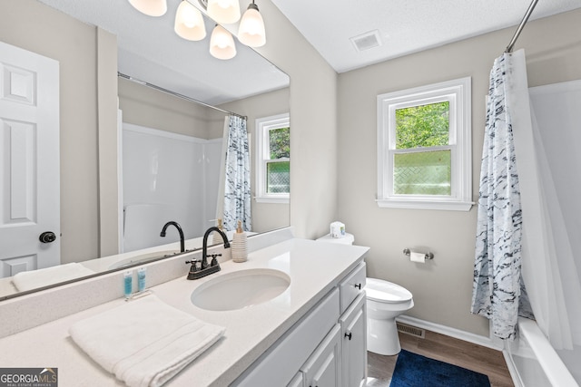 bathroom with wood finished floors, visible vents, toilet, vanity, and baseboards