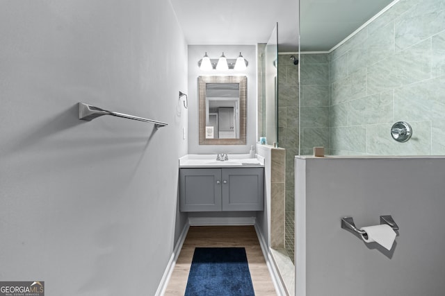 bathroom with baseboards, walk in shower, vanity, and wood finished floors