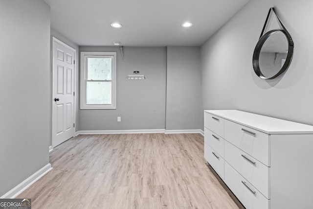 interior space featuring baseboards, light wood finished floors, and recessed lighting