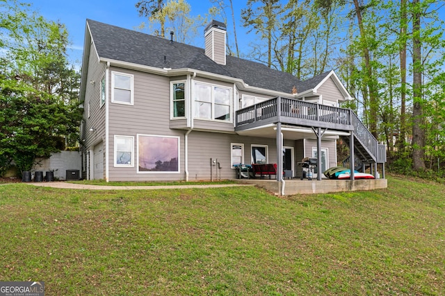 rear view of property featuring cooling unit, a chimney, a deck, a yard, and a patio