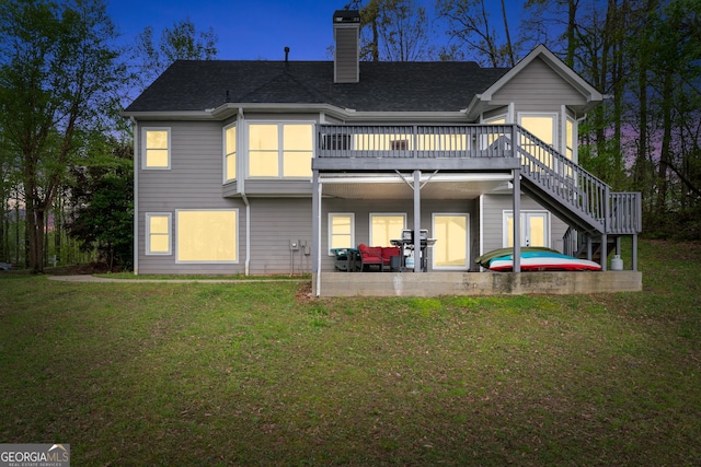 back of house with stairway, a chimney, a yard, a patio area, and a deck