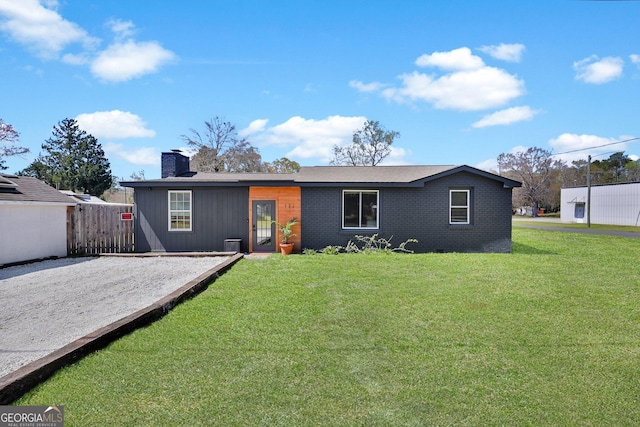132 4th St, Meldrim, GA 31318 - view of front facade featuring gravel driveway, a front lawn, fence, and a chimney