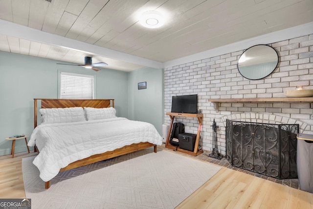 132 4th St, Meldrim, GA 31318 - bedroom with a brick fireplace, beam ceiling, wood ceiling, and wood finished floors