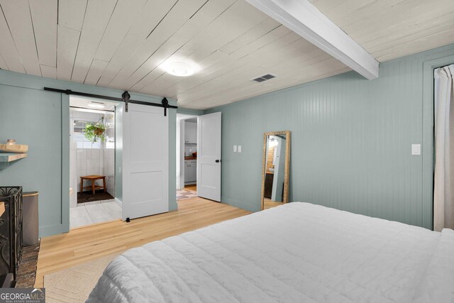 132 4th St, Meldrim, GA 31318 - bedroom featuring beamed ceiling, wooden ceiling, a barn door, and wood finished floors