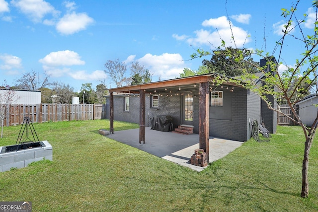 132 4th St, Meldrim, GA 31318 - rear view of house featuring brick siding, a fenced backyard, a lawn, and a patio area