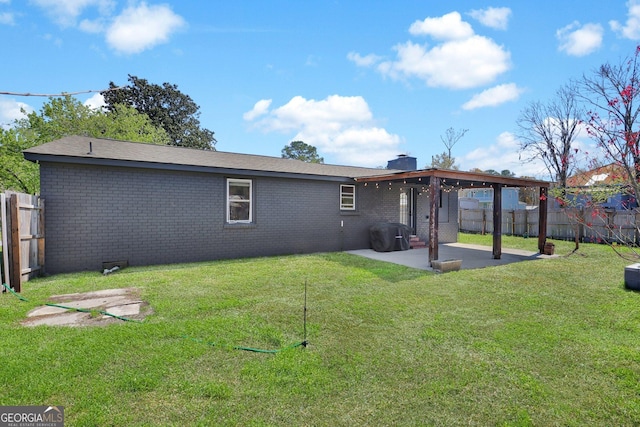 132 4th St, Meldrim, GA 31318 - back of property with brick siding, a patio area, a lawn, and a fenced backyard