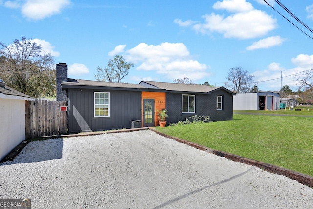 132 4th St, Meldrim, GA 31318 - view of front of house with gravel driveway, a front yard, fence, and a chimney