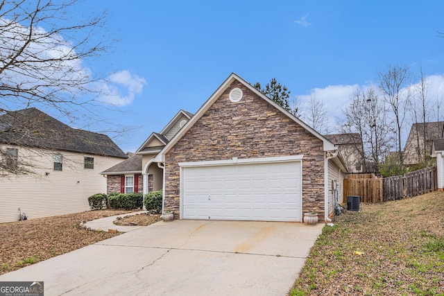 view of front facade with fence, concrete driveway, cooling unit, a garage, and stone siding
