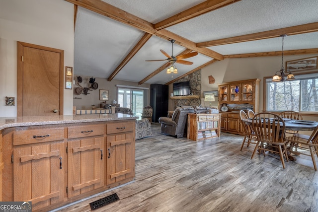 625 Sunnyside Shores Rd, Hiawassee, GA 30546 - kitchen with visible vents, vaulted ceiling with beams, light wood-style flooring, ceiling fan with notable chandelier, and a textured ceiling
