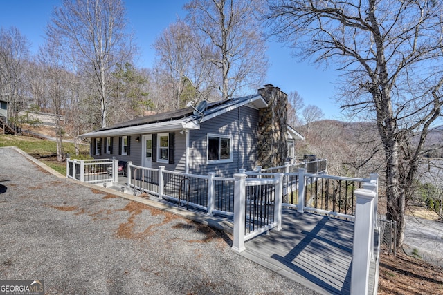 625 Sunnyside Shores Rd, Hiawassee, GA 30546 - view of front of home featuring a porch, roof mounted solar panels, and a chimney